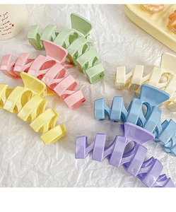 Vue détaillée de pinces à cheveux scintillantes aux couleurs pastel et design ondulé