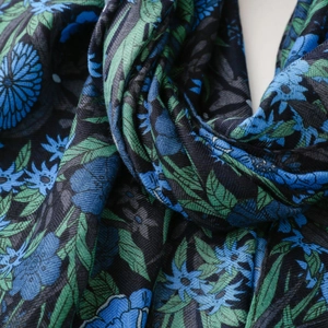 Macro shot of ethnic floral print scarf showing detailed texture and blue flower patterns