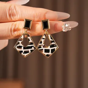 Luxurious geometric square resin earrings with gold trim and black white checkered pattern