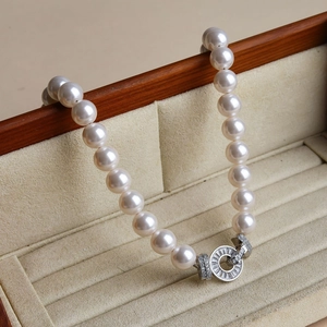 Detail of luxury pearl necklace with silver diamond-set clasp on a wooden box