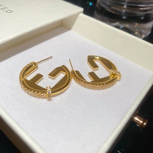 Detailed close-up of 18K gold plated S925 silver hoop earrings with F-logo and zircon pavé
