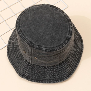 Chapeau bob en denim délavé gris anthracite avec œillets d'aération métalliques sur fond neutre