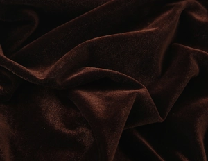 Gros plan du velours chocolat noir montrant le drapé lisse et la texture luxueuse du tissu