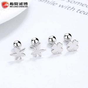 Macro detail of 925 silver four-leaf clover and maple leaf stud earrings with screw backs
