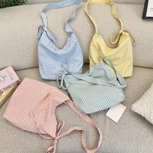 Detail of colorful gingham canvas tote bags with elegant bow tie shoulder strap design