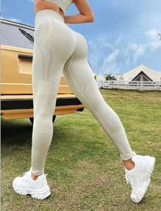 Détail du legging de yoga beige à taille haute avec texture sans couture et effet liftant