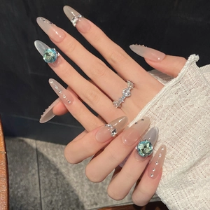 Long almond press-on nails with light blue square gems and jelly pink base color
