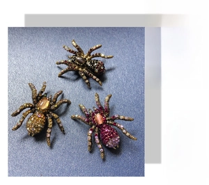 Detailed close-up showing three vintage spider brooches with opals and colorful crystals