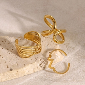Three-piece gold stainless steel ring set with twist and face silhouette designs