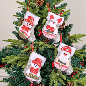 Christmas stockings set with Santa, snowman, and reindeer hanging on a festive pine tree