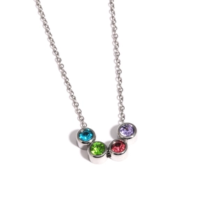 Détail de quatre pierres de zircon rondes colorées serties sur un collier en argent