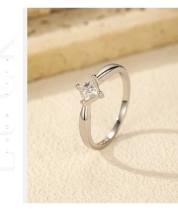 Macro view of princess cut moissanite ring with four-prong setting on silver band