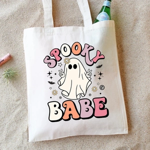 White Halloween canvas tote bag with Spooky Babe ghost print on a sandy background