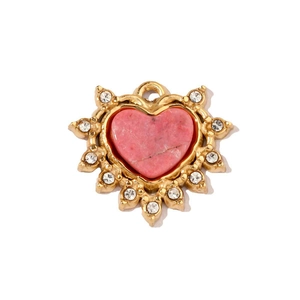 Dettaglio del ciondolo a cuore in pietra rosa con cornice dorata a raggiera e cristalli