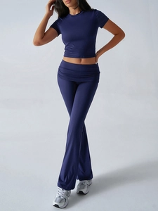 Detail of dark blue short-sleeve crop top and flared pants yoga set in stretch fabric