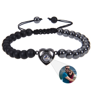 Detail of tiger eye bead bracelet with heart projection charm and adjustable braided cord