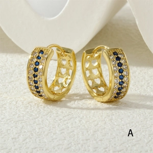 Detail of gold ear hoops featuring blue cubic zirconia and side hollow heart patterns