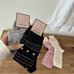 Détail de chaussettes d'hiver en maille avec motifs de flocons et de cœurs en couleurs