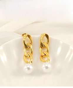 Detail of 18K gold-plated Cuban chain earrings with white pearl on white silk background
