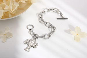 Detailed view of silver chunky chain bracelet with tree of life charm and T-bar toggle clasp