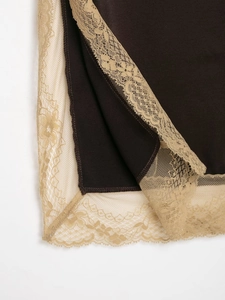 Detailed macro view of delicate lace trim on dark brown and beige satin fabric