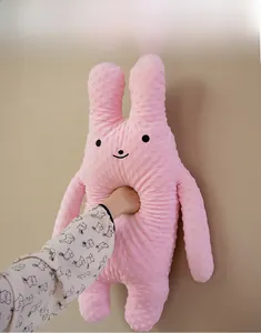 Detailed shot showing high-elasticity filling of pink plush rabbit being squeezed