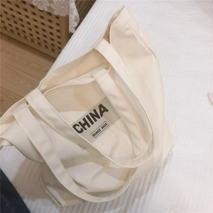 Détail d'un grand sac cabas en toile crème avec impression CHINA noire robuste
