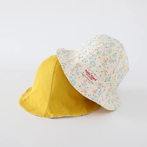 Détail d'un chapeau de soleil réversible en coton jaune et imprimé fleuri pour enfants