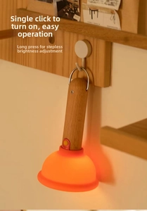 Portable bedside night light with wooden handle and warm LED glow hanging on a hook