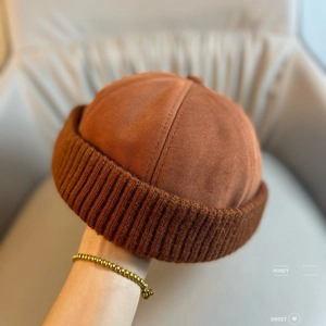 Detail of caramel brown corduroy and knit patchwork docker hat with side text