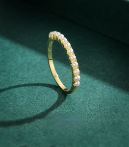 Macro shot of 925 sterling silver ring with gold finish and 11 round white pearls