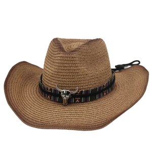 Détail d'un chapeau de cowboy en paille avec bande ethnique et ornement de crâne de taureau