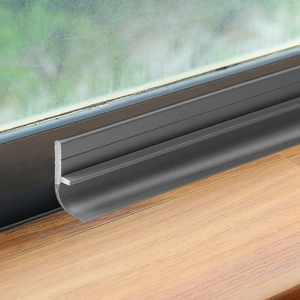 Gray flexible door bottom seal strip for soundproofing and weatherproofing on wood door
