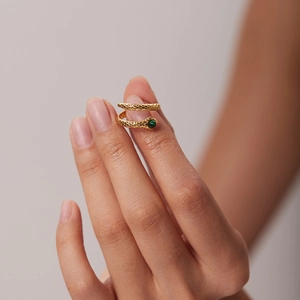 Detailed view of 18K gold plated snake ring with green malachite zircon on a hand