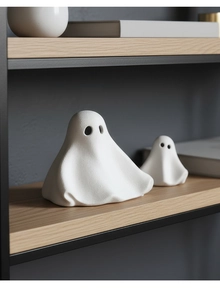 Detailopname van minimalistische witte keramieken spookjes op een houten plank voor decor
