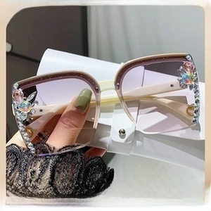 Detail of rimless butterfly sunglasses with rhinestone trim and gradient purple lenses