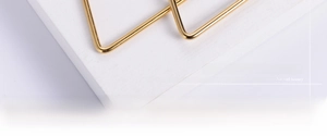 Close-up of sleek golden titanium steel hoop earring showing fine wire craftsmanship