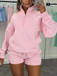 Dettaglio della felpa rosa con mezza zip e pantaloncini con coulisse sulla modella