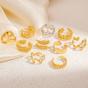 Macro shot of gold and silver leaf pattern adjustable rings on textured fabric background
