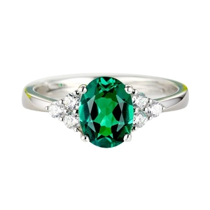Elegant emerald ring with oval green stone and side diamonds on silver band
