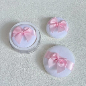 Three soft crystal velvet powder puffs with pink bows and a clear storage container