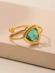 Detailopname van een 18K vergulde open ring met een driehoekige groene glassteen