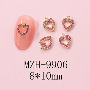 Detailed view of 8x10mm gold metal heart nail charms with pink rhinestones for Y2K style