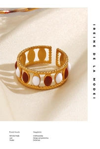 Detailed macro shot of gold stainless steel ring with red and white enamel detailing