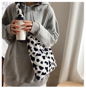 Chic cow print faux fur crossbody bag shown in a casual lifestyle setting for women