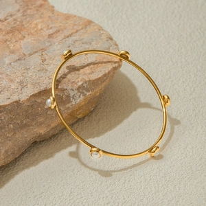 Dettaglio del bracciale in acciaio inossidabile placcato oro 18K con sei perle bianche