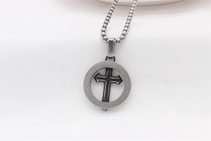 Détail d'un pendentif croix vintage en argent avec anneau sur chaîne box en acier