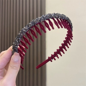 Detail of burgundy non-slip headband with sparkling grey crystal rhinestones held in hand