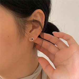 S925 sterling silver heart stud earrings with black drip glaze on model's ear