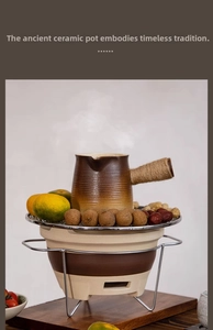 Close-up of a retro ceramic teapot set with heating base, metal grill, and steaming tea